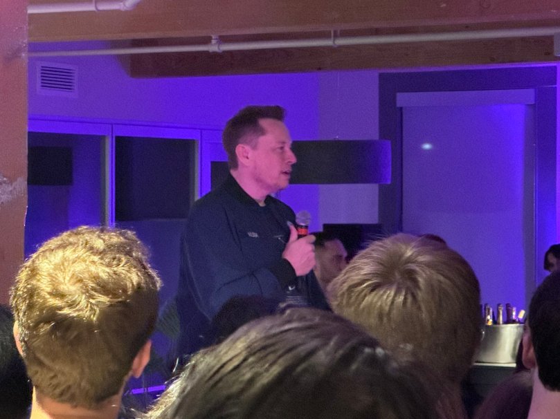 Elon Musk speaks to the xAI engineering team during an internal gathering in October 2024. Photo credit: Teknium (@Teknium ) via X. This rare behind-the-scenes image captures the collaborative energy behind Grok Imagine, video understanding, and Elon Musk’s photon-driven vision for AGI at xAI.